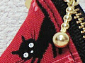 赤地に黒ネコの柄のテトラポーチの写真